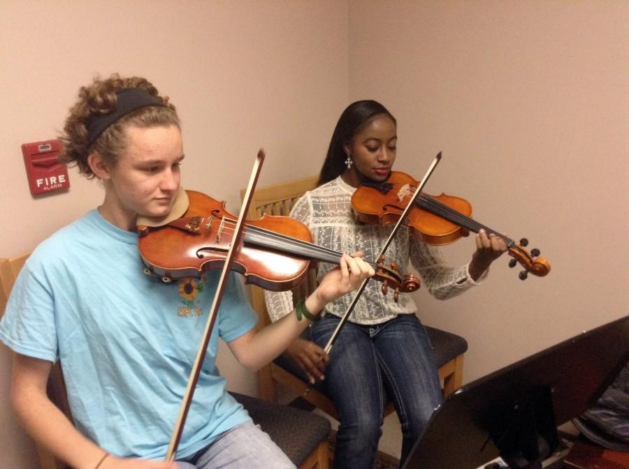 Junior Lillian Fulgham and senior Katelyn Jackson prepare for this Fridays Strings Symposium.