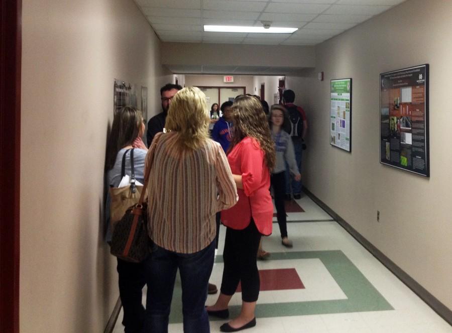 Students and tourists of MSMS crowd the upstairs Hooper hallway walking to classes or prepping for labs between research posters of former MSMS research students.