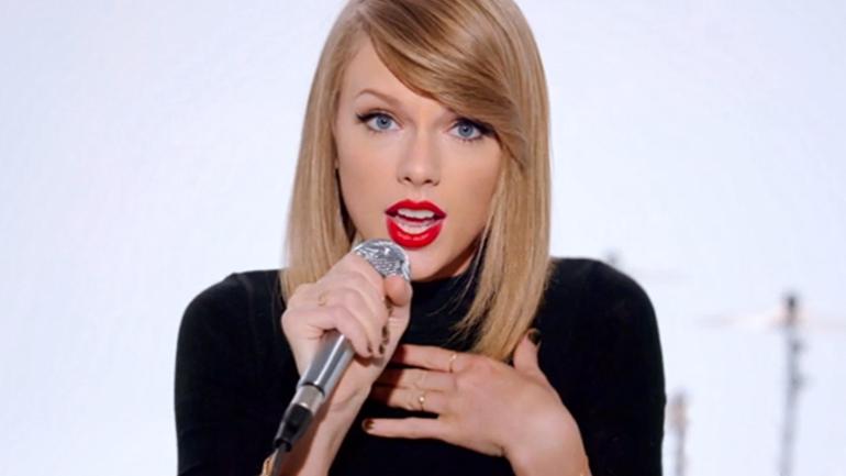 Taylor Swift singing in her Shake it Off music video.