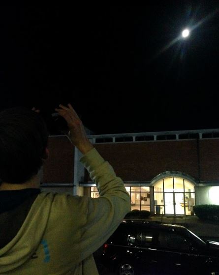 Junior Keegan Lindsay looks at the supermoon through binoculars. 