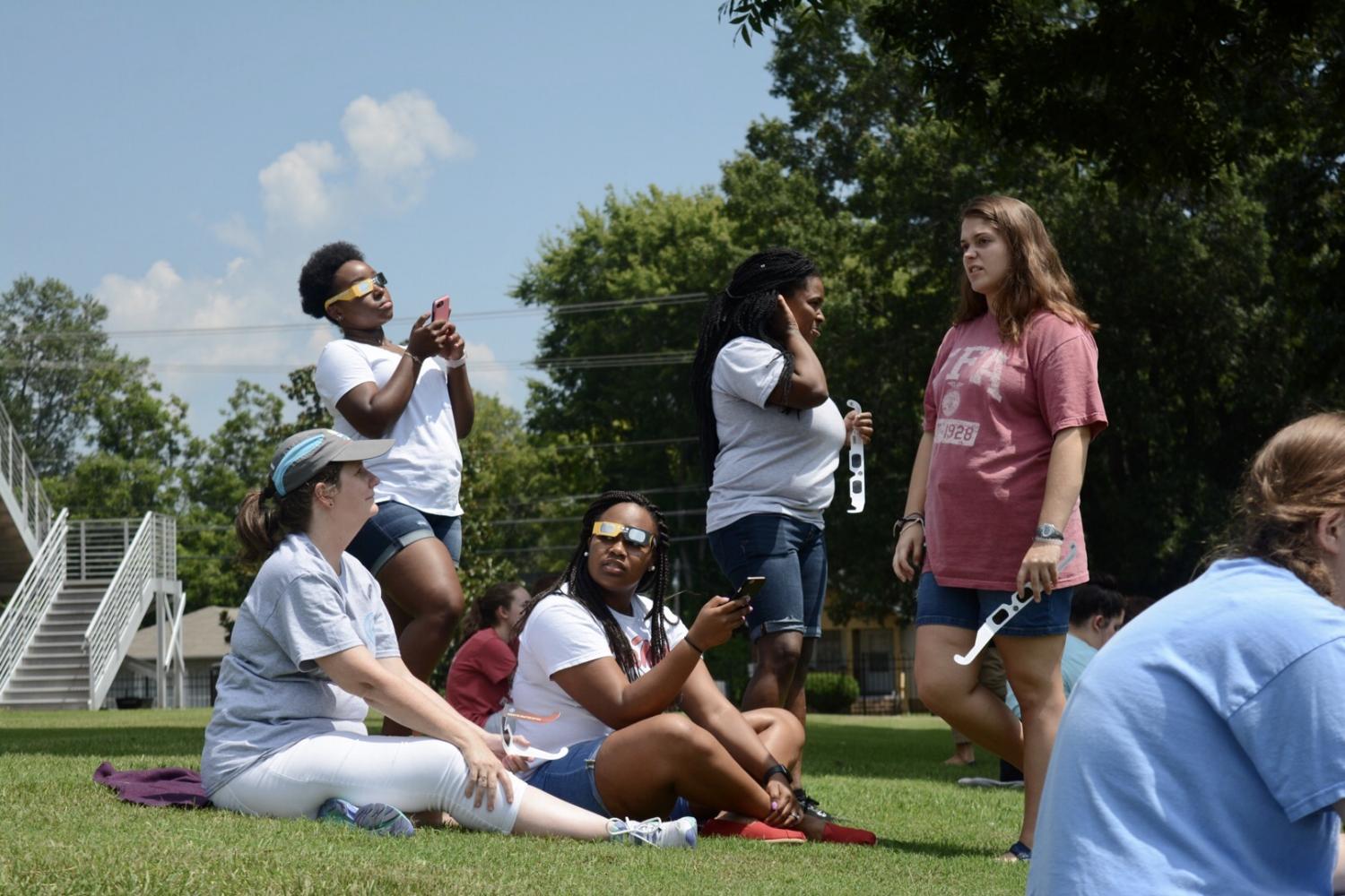 Mrs. Truitt (far left) sits with students Vivia Davis, Scooby Caine, Hannah Craft, and AK Mynatt during the eclipse viewing party. 