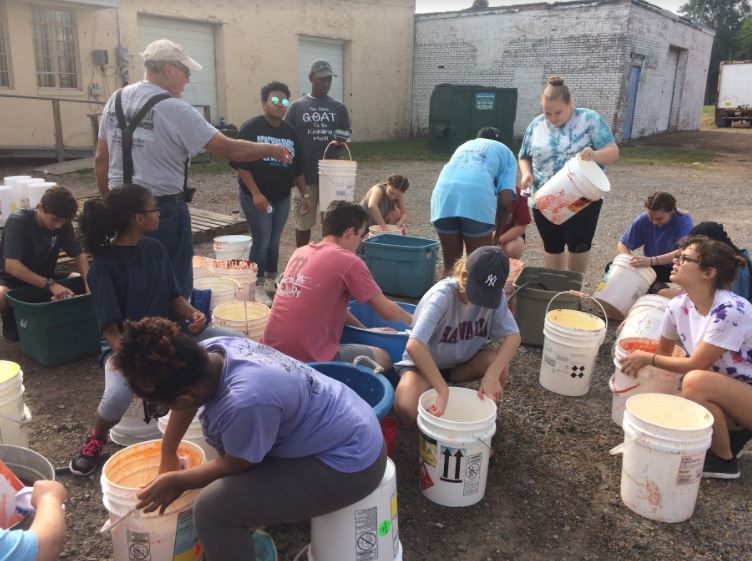 Students volunteer to wash and package water buckets for Operation Ukraine on Saturday. 