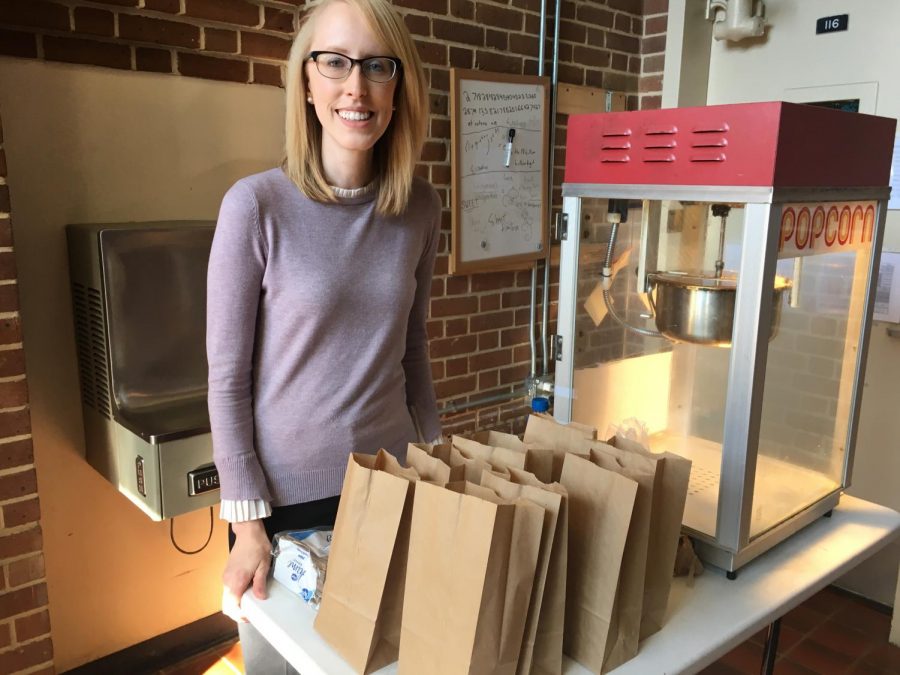 Dr. Hester prepares popcorn and a movie at the Forgotten Stories charity event. 