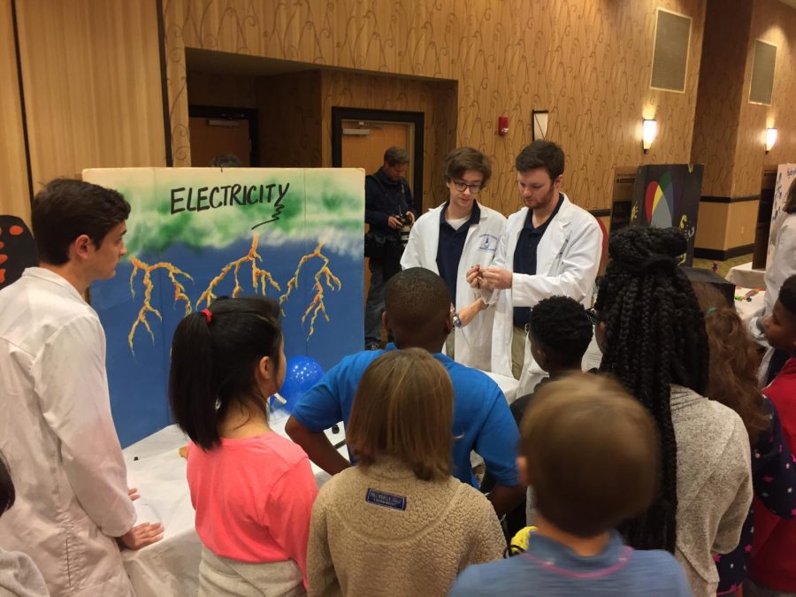 Tate Howard, MSMS Senior, and Liam McDougal, MSMS Senior, explain electricity to children visiting the Science Carnival.