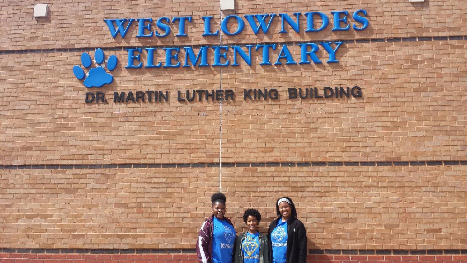 Three Blu Diamondz members, Tija Johnson, Ashley McPherson, and Ta'Kiya Moore, prepare for the Easter Egg Hunt and book reading at West Lowndes Elementary School.
