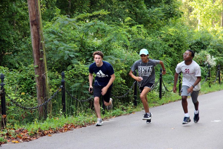 Cross Country team members Jonathan Morgigno, Hailey Desai, and Jaylen Hopson run through downtown Columbus.