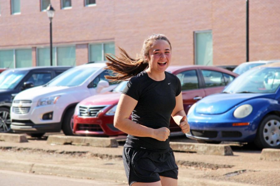 Senior Madison Wypyski warms up before practice by jogging.