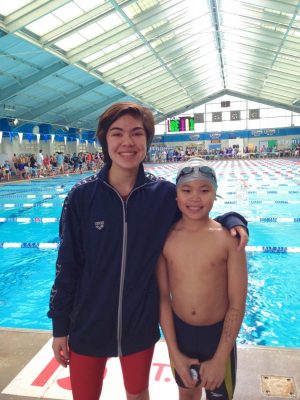 Sara stands with her younger cousin at the Biloxi Natitorium during a swim meet.