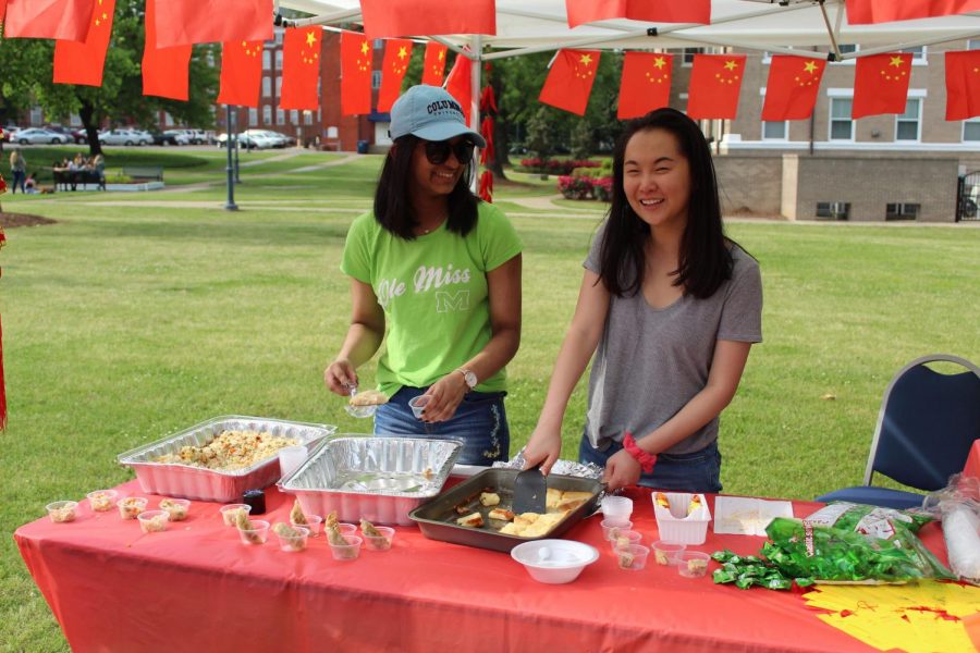 Sarena Patel and Helen Peng hand out fried rice, dumplings, and pastries at China's booth.