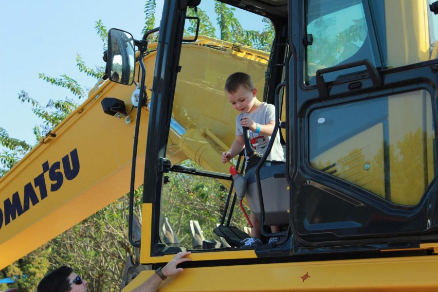 A child looks at the different functions in side the excavator. 