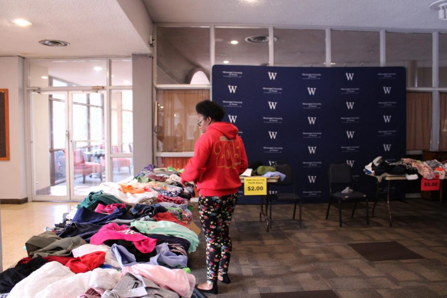 A student looks at one of the tables of donated clothes, hoping to get a steal.