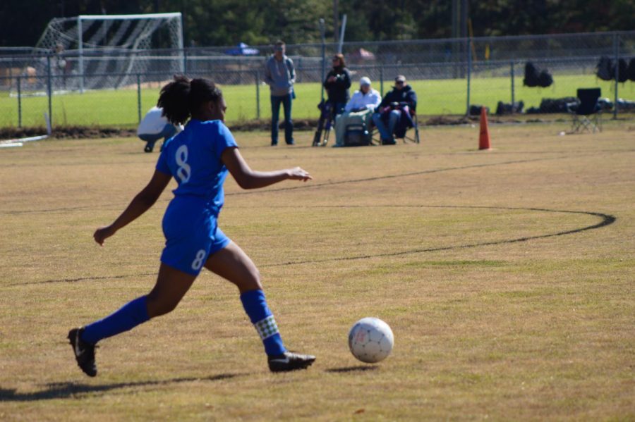 Captain Tierah Macon runs to kick the ball.