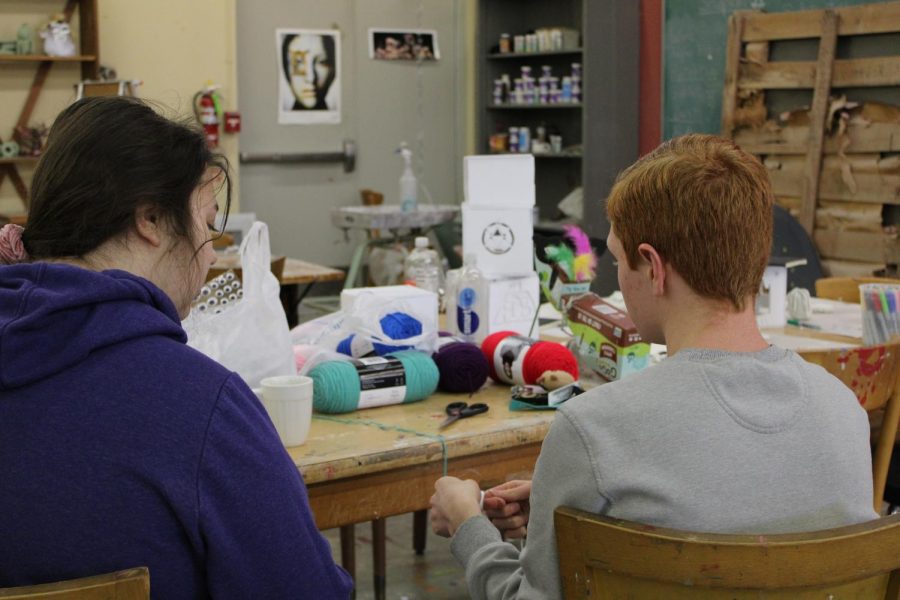 John Conn teaches Ryley Fallon how to make a yarn animal.