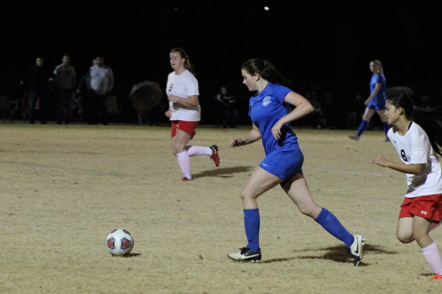 Senior Samantha Holland rushes the ball down to the goal.