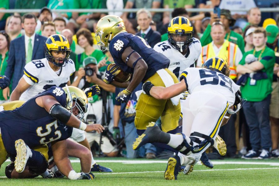 The Michigan Wolverines (white jerseys) play in the Big 10, which has already canceled its season. Notre Dame (blue jerseys) play as independents, leading to numerous challenged with game cancelations.
