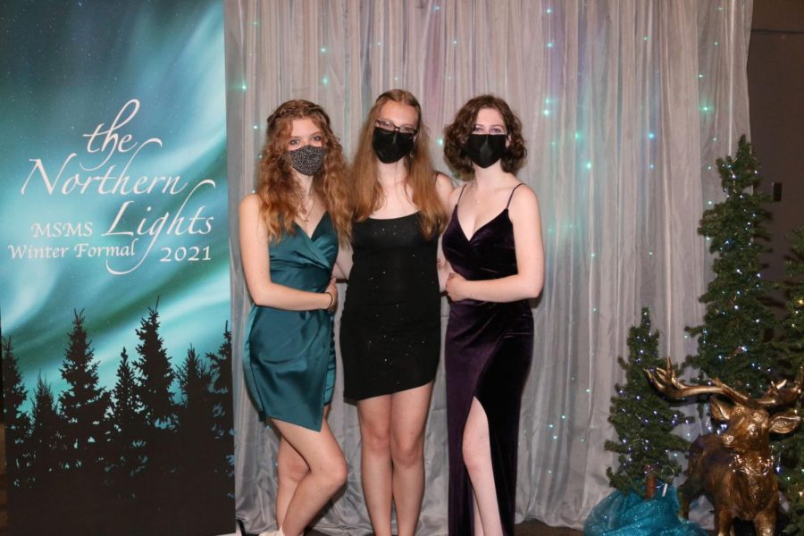 Seniors Audrey Robinson, Chloe Sharp and Jay Snodgrass pose for a portrait at the Winter Formal photo booth.