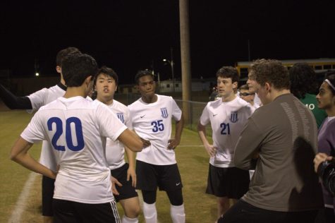 Members of the boys soccer team discuss plays on the sidelines.