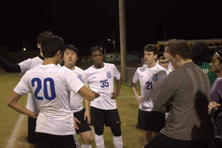Members+of+the+boys+soccer+team+discuss+plays+on+the+sidelines.