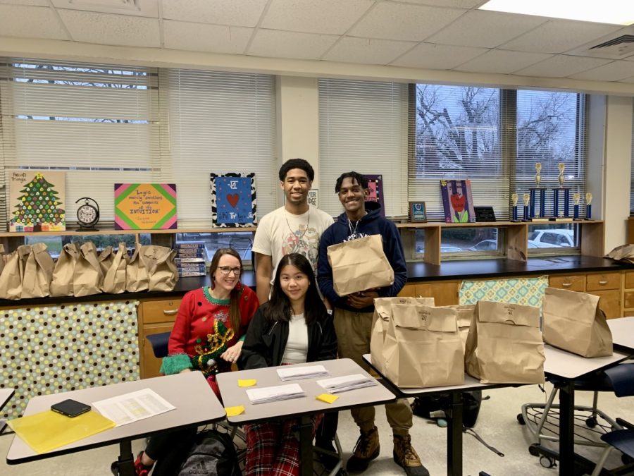 Three senior class officers pose with math teacher Shae Koenigsberger and exam snack packages for finals week. Pictured from left to right are C.J. Jordan (back), Kadie Van (front) and C.J. Mason. 