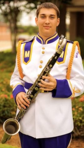 Junior Holden Herbert stands in full Lions Band dress with his bass clarinet.