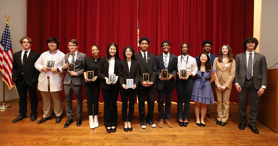 Thirteen Business Plan competitors pose for a group photo. Pictured from left to right are  seniors George Utz, Richard Zheng and JD Hagood; juniors Sydney Beane and Iris Xue; seniors Mandy Sun, CJ Jordan, CJ Mason and Sephora Poteau; juniors Julia Nguyen, Ashton Lollis and Maple Griffin; and senior Nicolas Neal. 