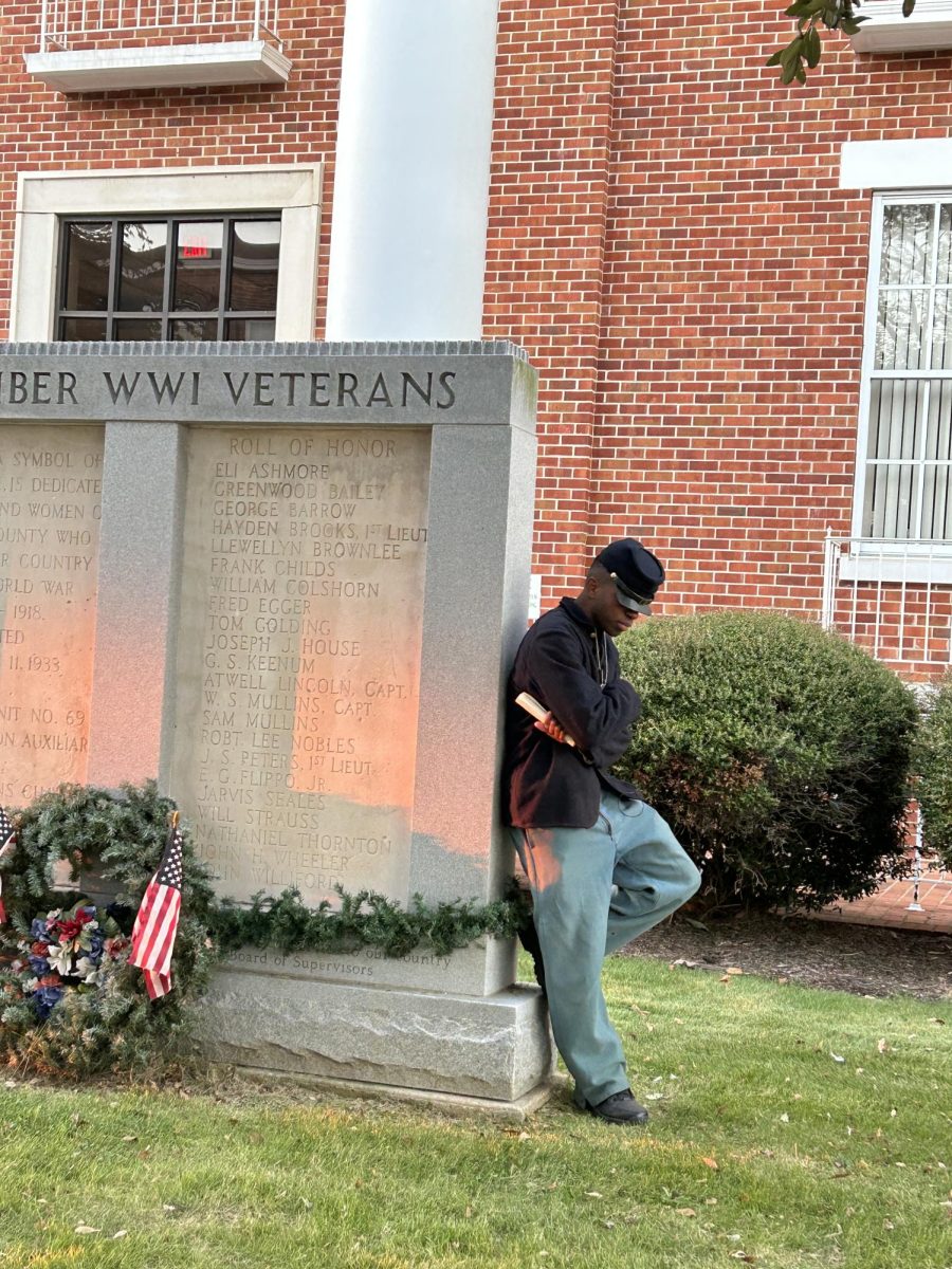 Senior Dylan Wiley poses next to Columbus monument honoring WWI veterans before performing as part of the Downtown Historical Performance Tour of Gleed’s Corner on Nov. 1.