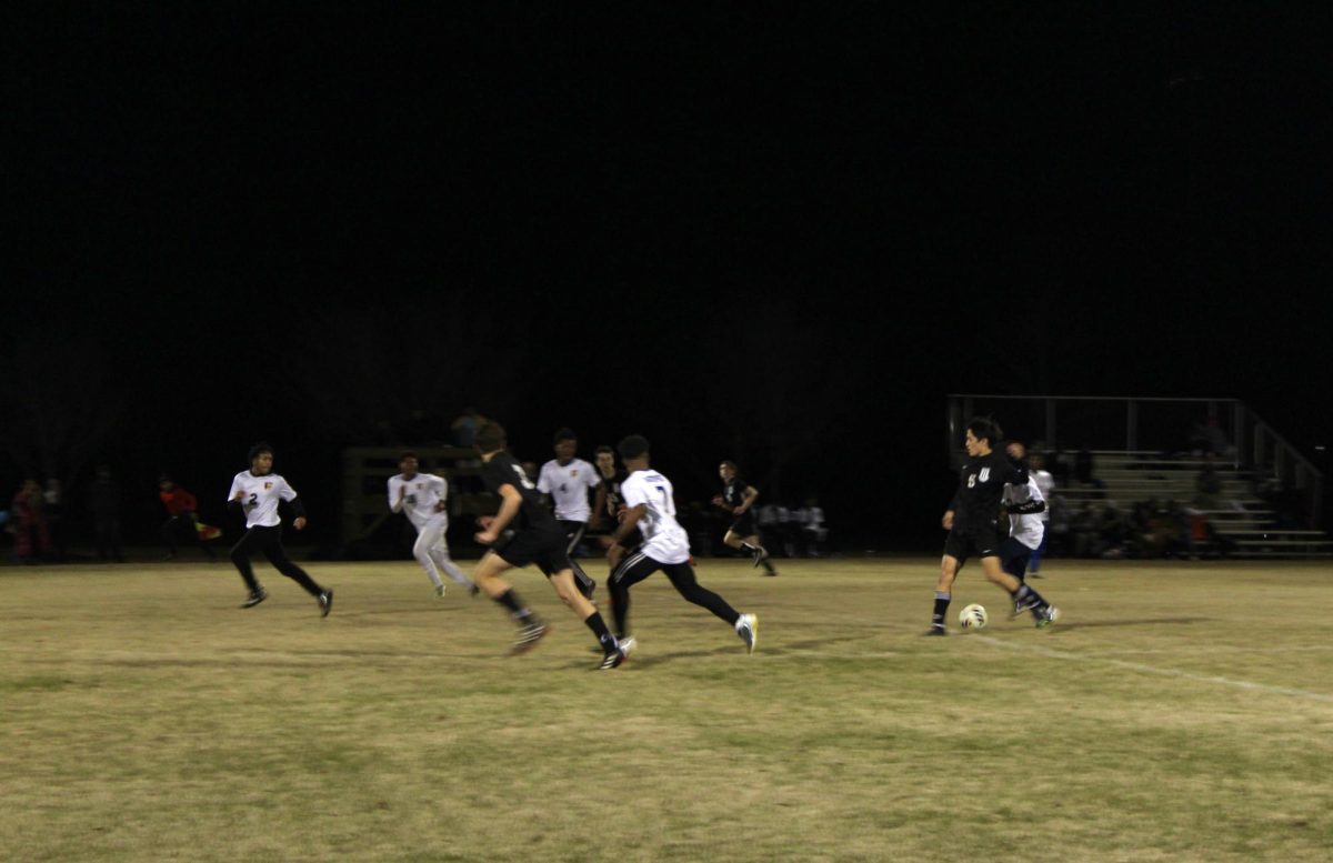 Senior midfielder Ethan Liao (right) passes the ball to senior co-captain and striker Sebastian Harvey advancing over the pitch during Frazers senior night match against Kemper County on Jan. 22.