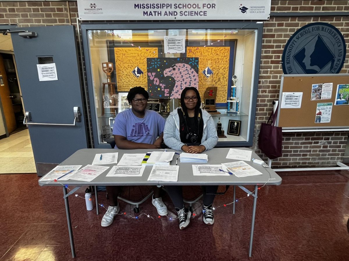 Seniors Maurice Hunter (left) and Joy Barner set up a table in Hooper lobby to register voters.