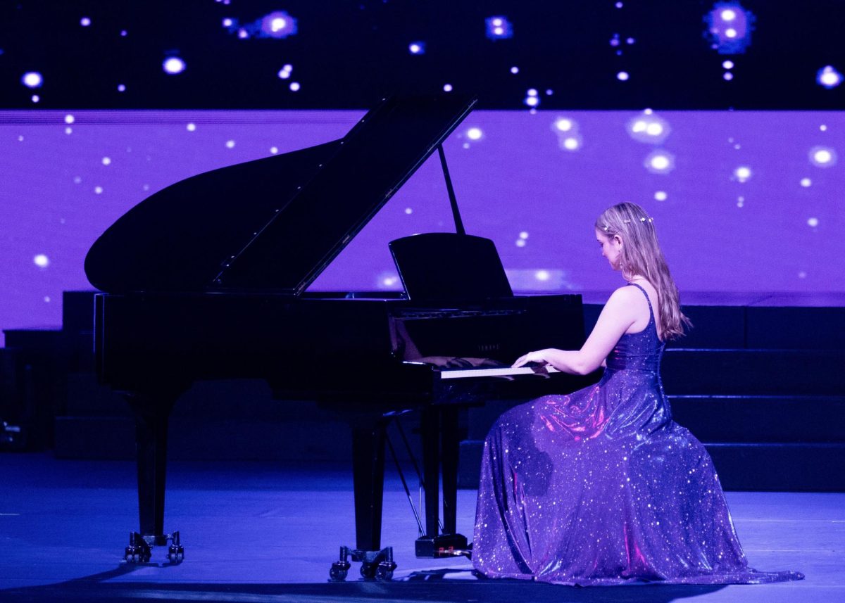 Senior Grace Ann Courtney performs her piano piece, "Clair de Lune" by Claude Debussy, on stage in front of a panel of judges and a live audience.