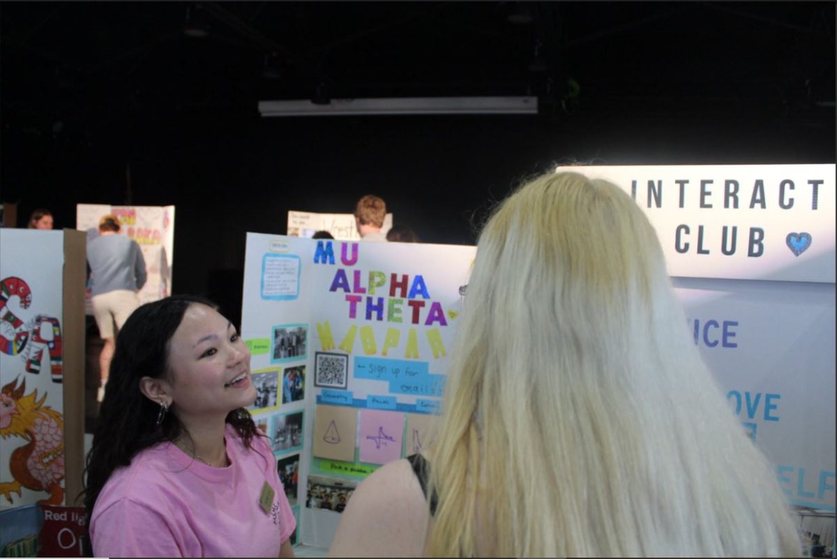 2025 graduate Jennifer Bui promotes Mu Alpha Theta and Interact Club at club fair. 