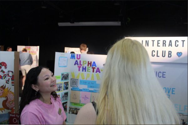 2025 graduate Jennifer Bui promotes Mu Alpha Theta and Interact Club at club fair. 
