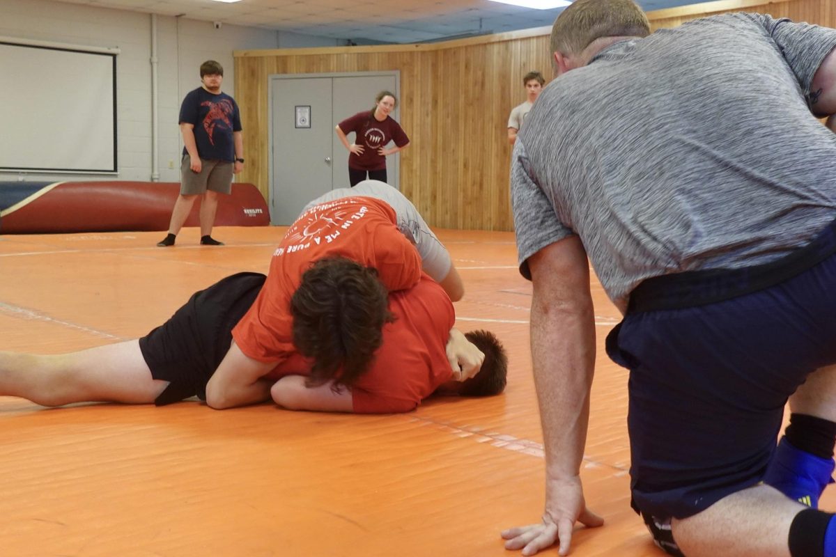 MSMS wrestlers Cyrus Savell (bottom) and Owen Williams practice with coach Chris Coover. 
