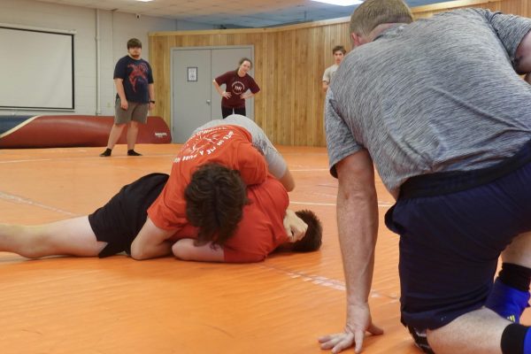 MSMS wrestlers Cyrus Savell (bottom) and Owen Williams practice with coach Chris Coover. 
