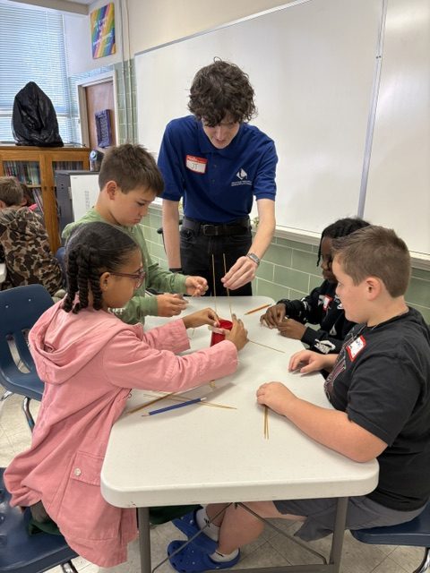 Senior JT Sistrunk helps third grade students construct a spaghetti tower during Math Superstars on Oct. 24.