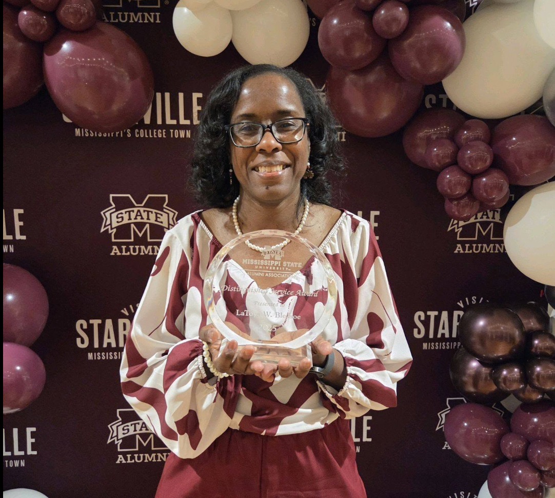 Latoya Bledsoe poses with her Mississippi State University Alumni Association Distinguished Service Award.