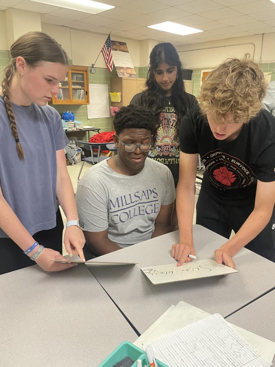 Junior Branston Harewood (center) learns tips and tricks from (from left) junior Sonora Foster, senior Simi Kaur and junior Hutch Clemons. 